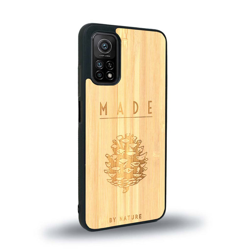 Coque de protection en bois véritable fabriquée en France pour Xiaomi Mi 10 Lite sur le thème de la nature et des arbres avec une gravure représentant une pomme de pin et la phrase "made by nature"