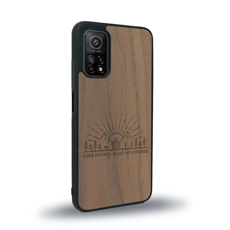 Coque de protection en bois véritable fabriquée en France pour Xiaomi Mi 10 Lite sur le thème chill et nature avec un motif représentant un levé de soleil sur un paysage de montagne avec des sapins et un chalet et la phrase "Good friends, good adventure"