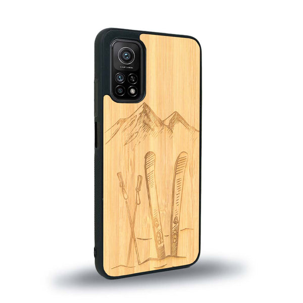 Coque de protection en bois véritable fabriquée en France pour Xiaomi Mi 10 Lite sur le thème de la montagne, du ski et de la neige avec un motif représentant une paire de ski plantée dans la neige avec en fond des montagnes enneigées