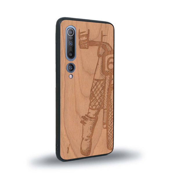 Coque de protection en bois véritable fabriquée en France pour Xiaomi Mi 10 représentant une vue de face d'une femme sur une moto vintage dessinée à la main par l'artiste Maud Dabs