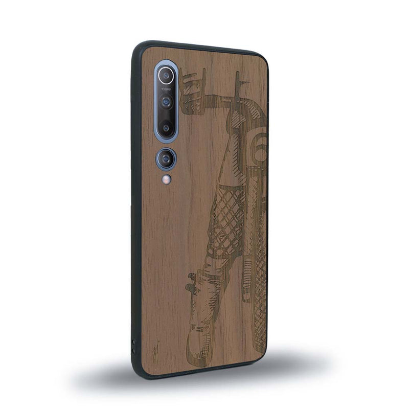 Coque de protection en bois véritable fabriquée en France pour Xiaomi Mi 10 représentant une vue de face d'une femme sur une moto vintage dessinée à la main par l'artiste Maud Dabs