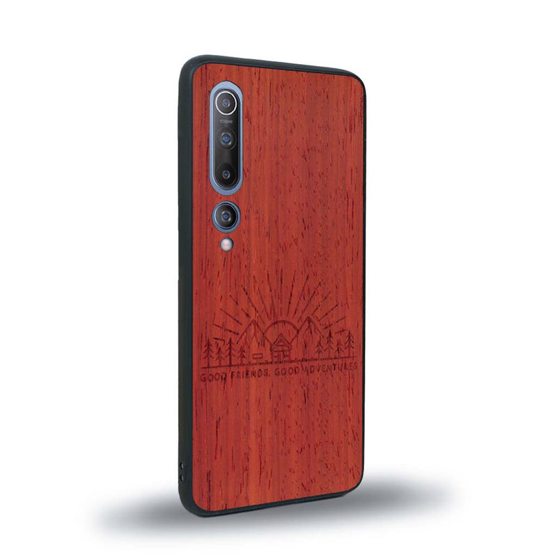 Coque de protection en bois véritable fabriquée en France pour Xiaomi Mi 10 sur le thème chill et nature avec un motif représentant un levé de soleil sur un paysage de montagne avec des sapins et un chalet et la phrase "Good friends, good adventure"