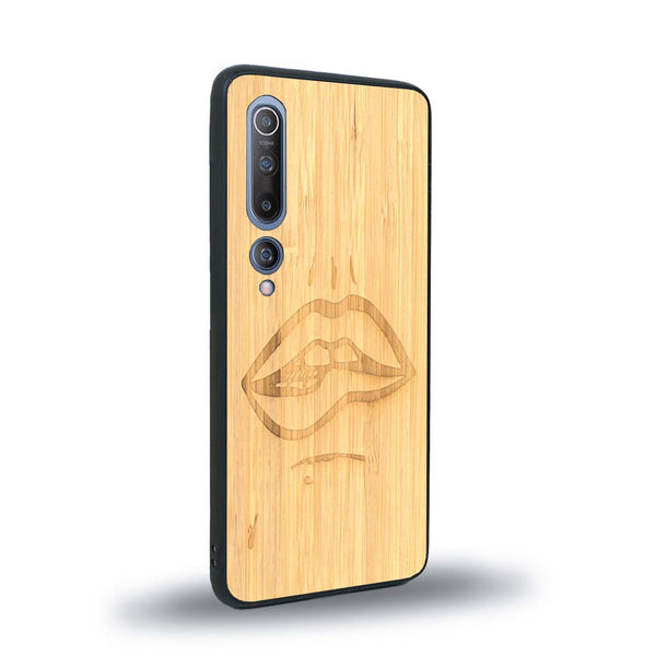 Coque de protection en bois véritable fabriquée en France pour Xiaomi Mi 10 représentant de manière minimaliste une bouche de féminine se mordant le coin de la lèvre de manière sensuelle dessinée à la main par l'artiste Maud Dabs