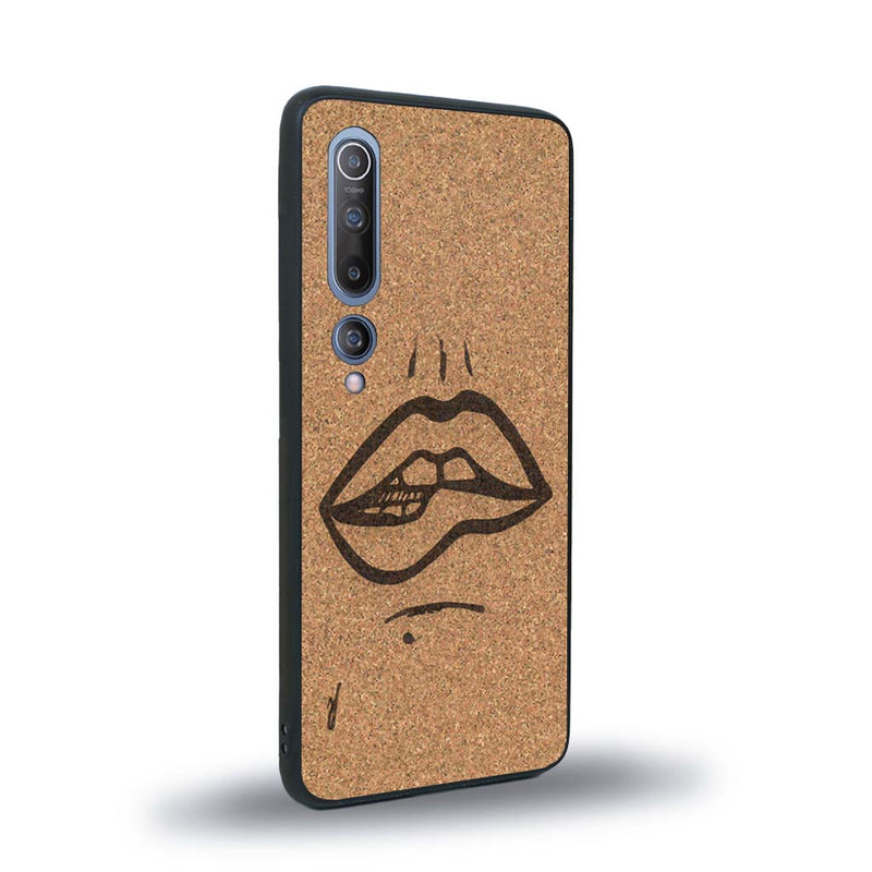 Coque de protection en bois véritable fabriquée en France pour Xiaomi Mi 10 représentant de manière minimaliste une bouche de féminine se mordant le coin de la lèvre de manière sensuelle dessinée à la main par l'artiste Maud Dabs