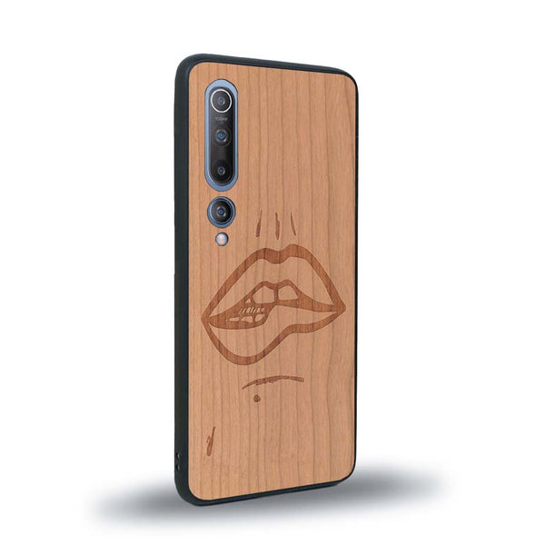 Coque de protection en bois véritable fabriquée en France pour Xiaomi Mi 10 représentant de manière minimaliste une bouche de féminine se mordant le coin de la lèvre de manière sensuelle dessinée à la main par l'artiste Maud Dabs