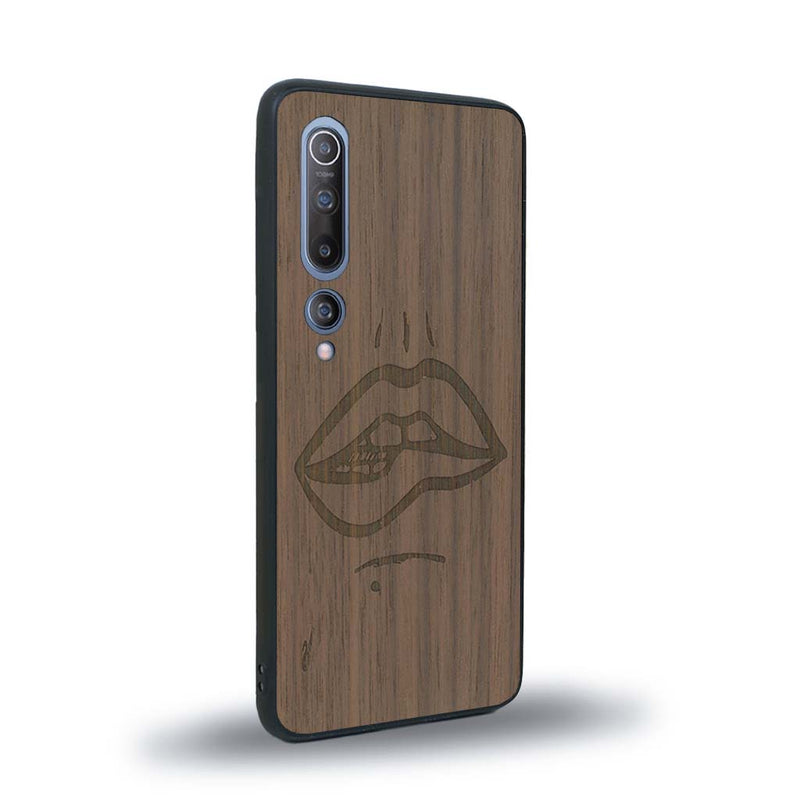 Coque de protection en bois véritable fabriquée en France pour Xiaomi Mi 10 représentant de manière minimaliste une bouche de féminine se mordant le coin de la lèvre de manière sensuelle dessinée à la main par l'artiste Maud Dabs