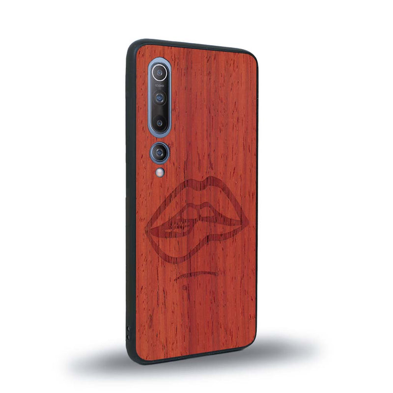 Coque de protection en bois véritable fabriquée en France pour Xiaomi Mi 10 représentant de manière minimaliste une bouche de féminine se mordant le coin de la lèvre de manière sensuelle dessinée à la main par l'artiste Maud Dabs