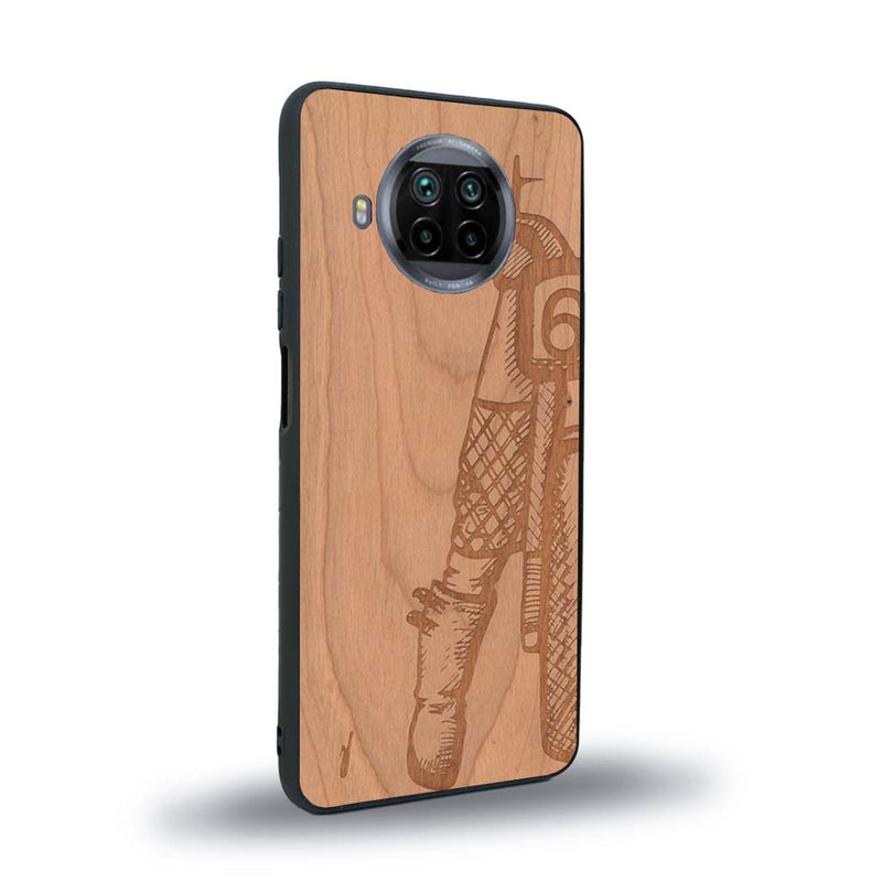 Coque de protection en bois véritable fabriquée en France pour Xiaomi Mi 10T Lite représentant une vue de face d'une femme sur une moto vintage dessinée à la main par l'artiste Maud Dabs