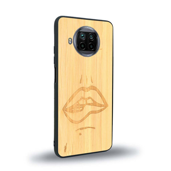 Coque de protection en bois véritable fabriquée en France pour Xiaomi Mi 10T Lite représentant de manière minimaliste une bouche de féminine se mordant le coin de la lèvre de manière sensuelle dessinée à la main par l'artiste Maud Dabs