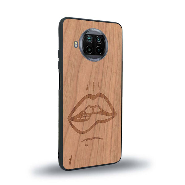 Coque de protection en bois véritable fabriquée en France pour Xiaomi Mi 10T Lite représentant de manière minimaliste une bouche de féminine se mordant le coin de la lèvre de manière sensuelle dessinée à la main par l'artiste Maud Dabs