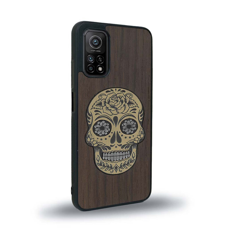 Coque de protection en bois véritable fabriquée en France pour Xiaomi Mi 10T Pro alliant du chêne fumé avec du métal argenté et doré représentant une tête de mort mexicaine sur le thème Dia de los Muertos