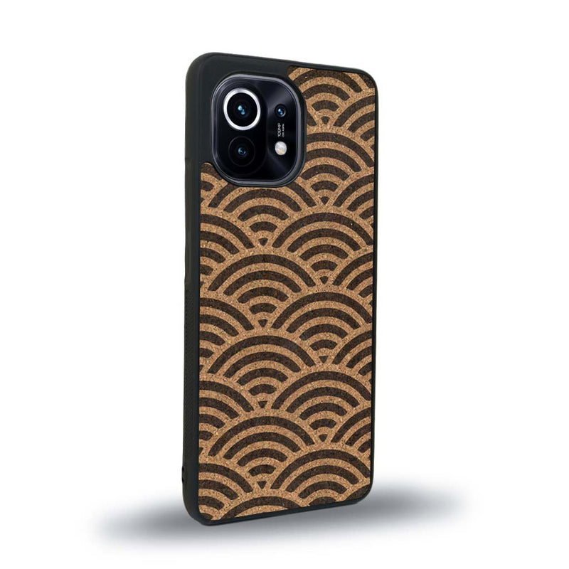 Coque de protection en bois véritable fabriquée en France pour Xiaomi Mi 11 baptisée "La Sinjak" avec un motif de gravure abstrait représentant la répétition d'un symbole wifi