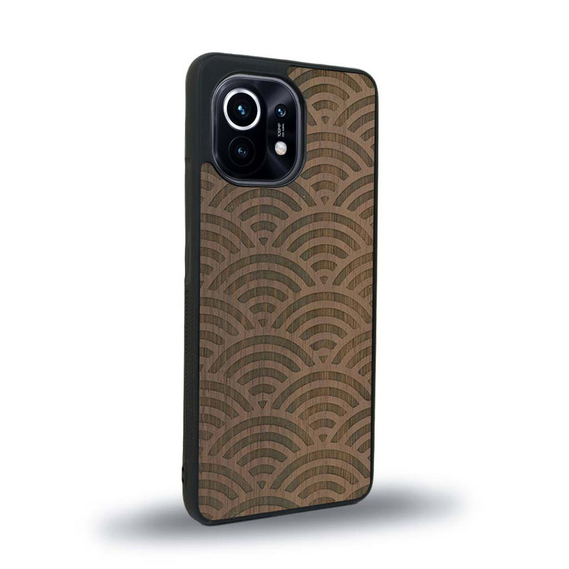 Coque de protection en bois véritable fabriquée en France pour Xiaomi Mi 11 baptisée "La Sinjak" avec un motif de gravure abstrait représentant la répétition d'un symbole wifi