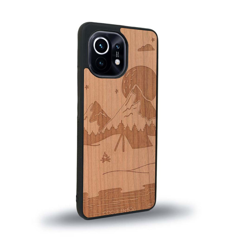 Coque de protection en bois véritable fabriquée en France pour Xiaomi Mi 11 sur le thème du camping en pleine nature représentant une tente avec un feu de camp entouré de montagnes