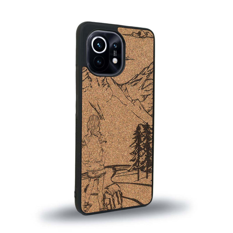Coque de protection en bois véritable fabriquée en France pour Xiaomi Mi 11 sur le thème de la randonnée en montagne et de l'aventure avec une gravure représentant une femme de dos face à un paysage de nature