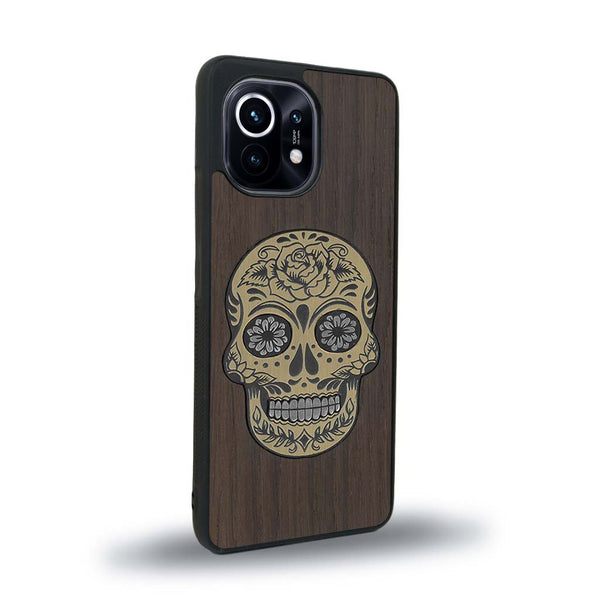 Coque de protection en bois véritable fabriquée en France pour Xiaomi Mi 11 Lite alliant du chêne fumé avec du métal argenté et doré représentant une tête de mort mexicaine sur le thème Dia de los Muertos