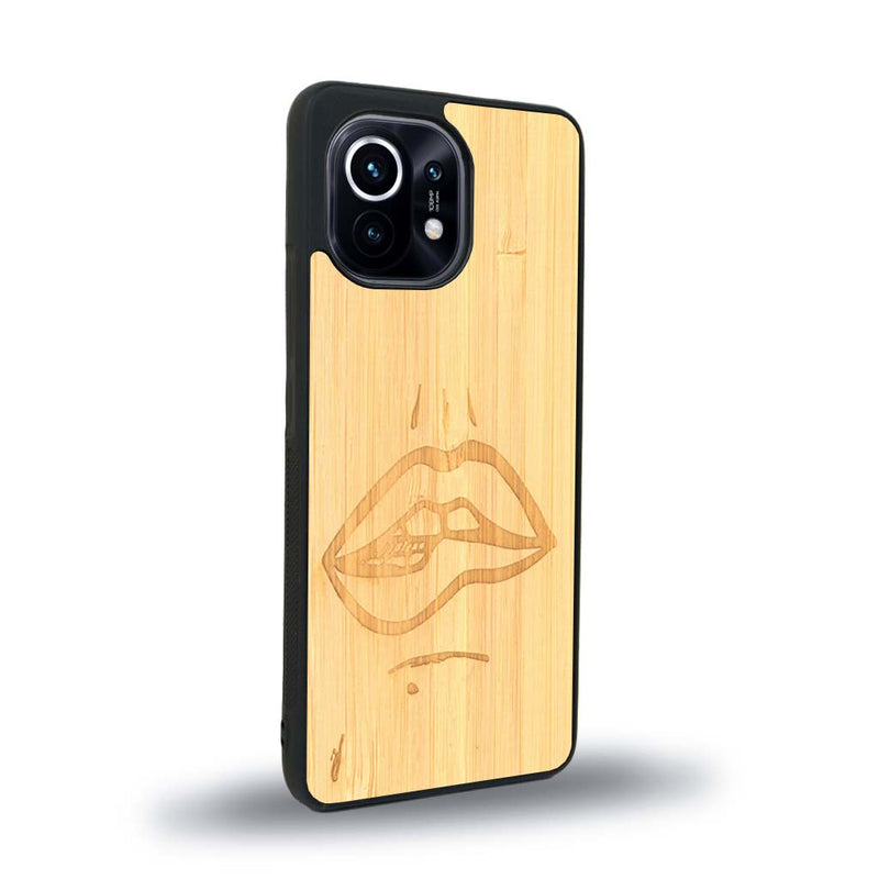 Coque de protection en bois véritable fabriquée en France pour Xiaomi Mi 11 Lite représentant de manière minimaliste une bouche de féminine se mordant le coin de la lèvre de manière sensuelle dessinée à la main par l'artiste Maud Dabs