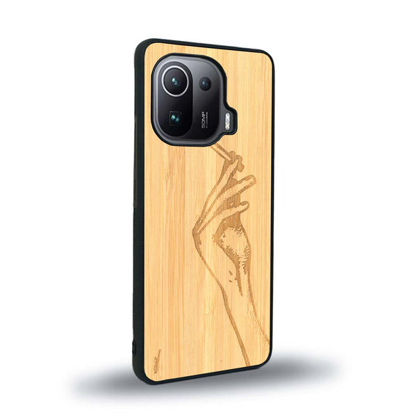 Coque de protection en bois véritable fabriquée en France pour Xiaomi Mi 11 Pro représentant une main de femme tenant une cigarette de type line art en collaboration avec l'artiste Maud Dabs