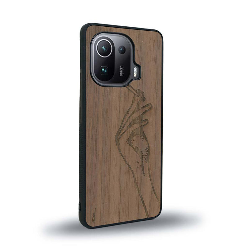 Coque de protection en bois véritable fabriquée en France pour Xiaomi Mi 11 Pro représentant une main de femme tenant une cigarette de type line art en collaboration avec l'artiste Maud Dabs