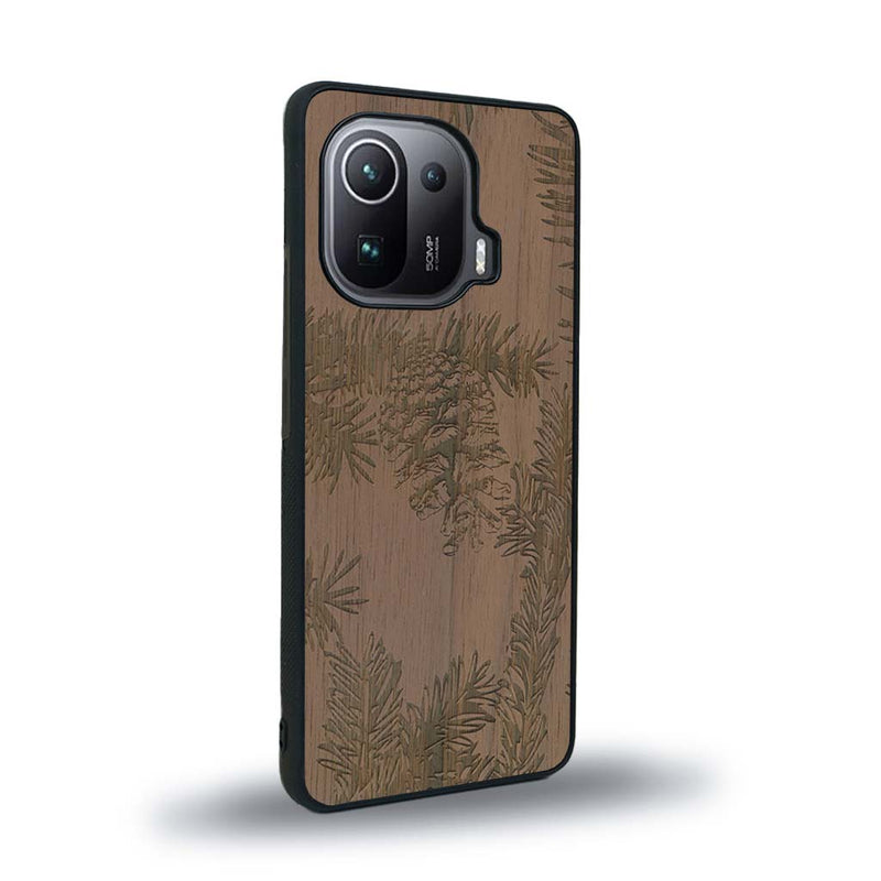 Coque de protection en bois véritable fabriquée en France pour Xiaomi Mi 11 Pro sur le thème de la nature des arbres avec un motif de gravure représentant des épines de sapin et des pommes de pin