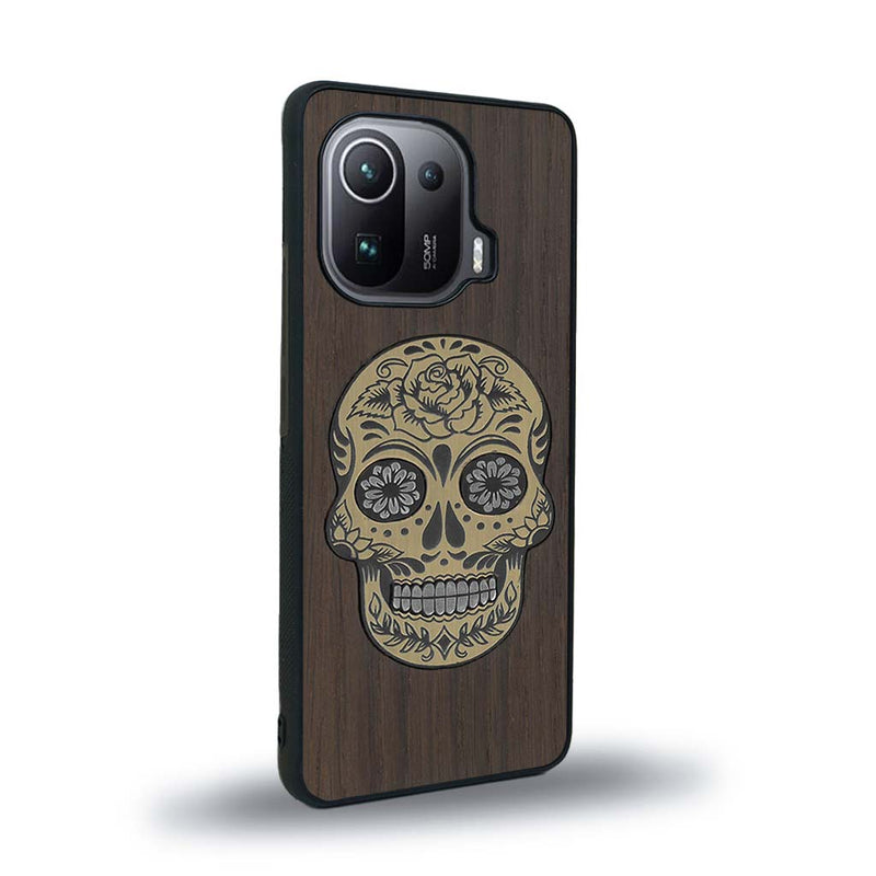 Coque de protection en bois véritable fabriquée en France pour Xiaomi Mi 11 Pro alliant du chêne fumé avec du métal argenté et doré représentant une tête de mort mexicaine sur le thème Dia de los Muertos