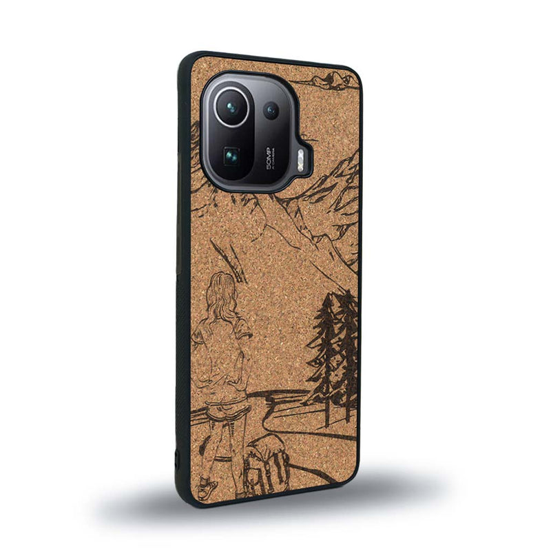 Coque de protection en bois véritable fabriquée en France pour Xiaomi Mi 11 Pro sur le thème de la randonnée en montagne et de l'aventure avec une gravure représentant une femme de dos face à un paysage de nature