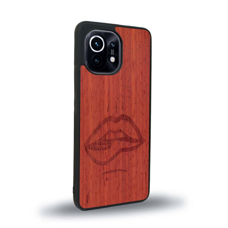 Coque de protection en bois véritable fabriquée en France pour Xiaomi Mi 11 représentant de manière minimaliste une bouche de féminine se mordant le coin de la lèvre de manière sensuelle dessinée à la main par l'artiste Maud Dabs