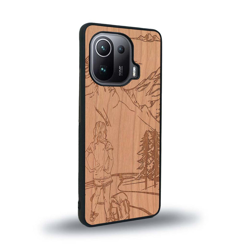 Coque de protection en bois véritable fabriquée en France pour Xiaomi Mi 11 Ultra sur le thème de la randonnée en montagne et de l'aventure avec une gravure représentant une femme de dos face à un paysage de nature