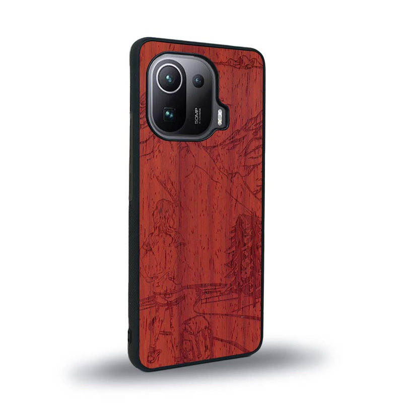 Coque de protection en bois véritable fabriquée en France pour Xiaomi Mi 11 Ultra sur le thème de la randonnée en montagne et de l'aventure avec une gravure représentant une femme de dos face à un paysage de nature