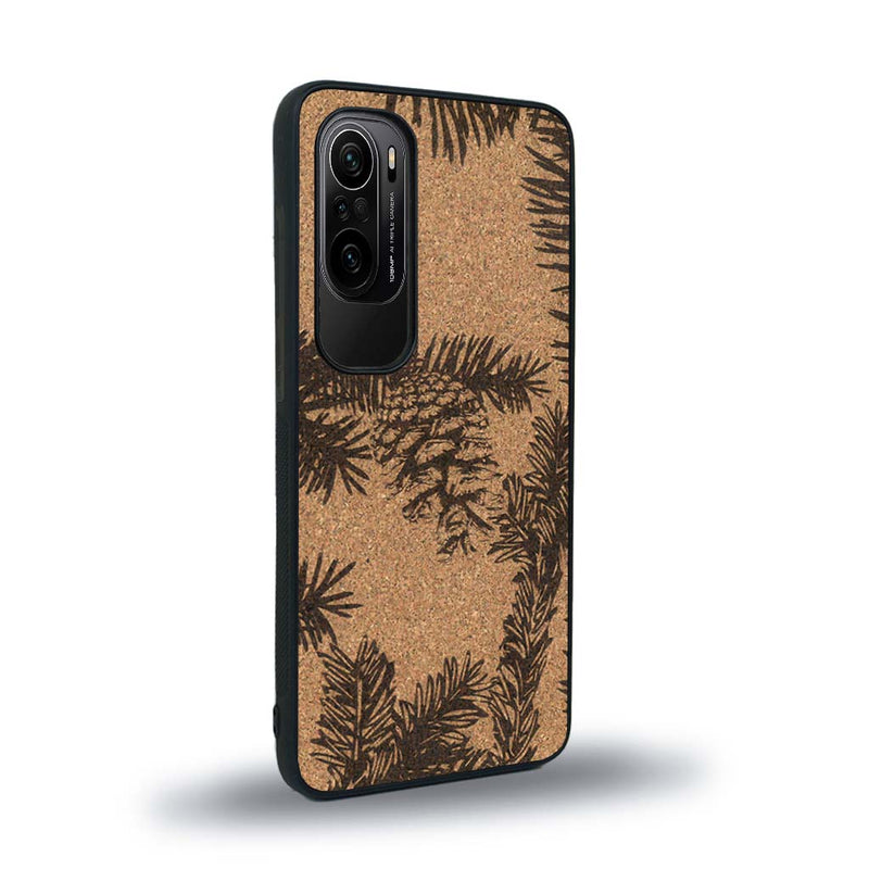 Coque de protection en bois véritable fabriquée en France pour Xiaomi Mi 11i sur le thème de la nature des arbres avec un motif de gravure représentant des épines de sapin et des pommes de pin