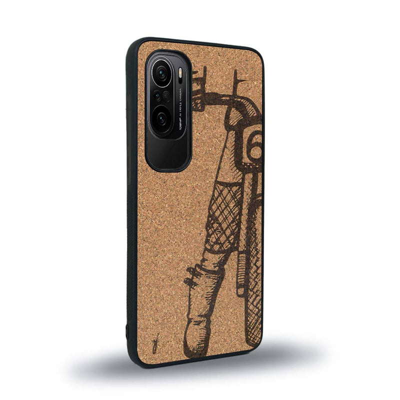 Coque de protection en bois véritable fabriquée en France pour Xiaomi Mi 11i représentant une vue de face d'une femme sur une moto vintage dessinée à la main par l'artiste Maud Dabs