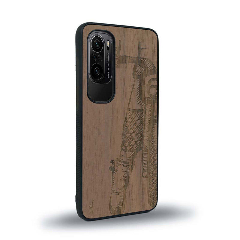 Coque de protection en bois véritable fabriquée en France pour Xiaomi Mi 11i représentant une vue de face d'une femme sur une moto vintage dessinée à la main par l'artiste Maud Dabs