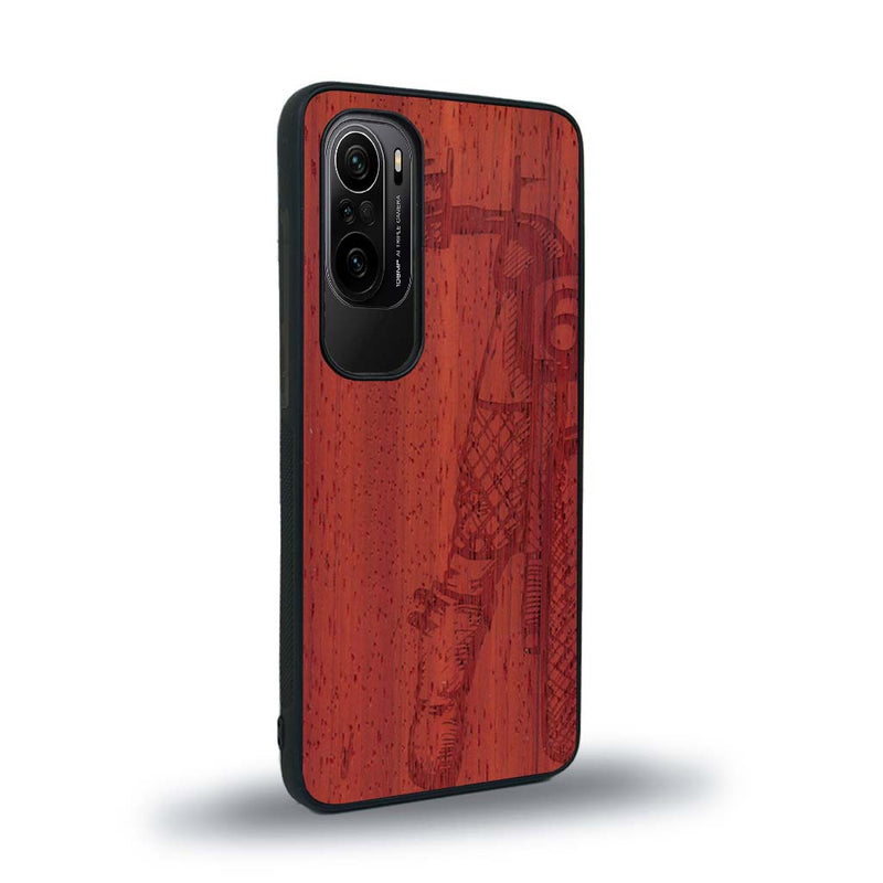 Coque de protection en bois véritable fabriquée en France pour Xiaomi Mi 11i représentant une vue de face d'une femme sur une moto vintage dessinée à la main par l'artiste Maud Dabs