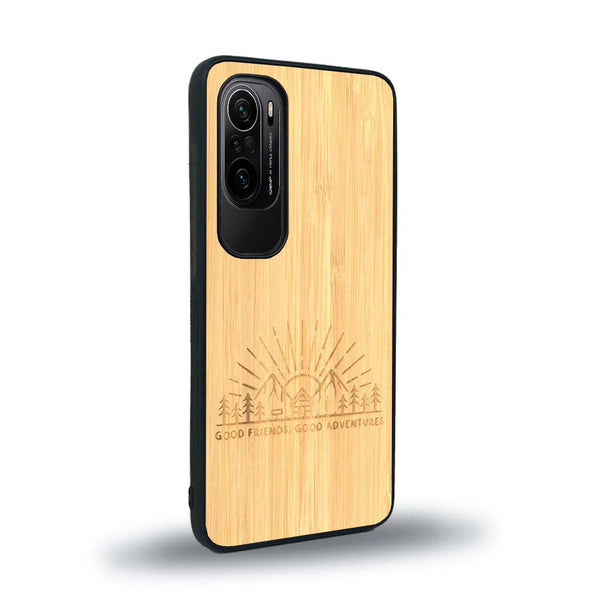 Coque de protection en bois véritable fabriquée en France pour Xiaomi Mi 11i sur le thème chill et nature avec un motif représentant un levé de soleil sur un paysage de montagne avec des sapins et un chalet et la phrase "Good friends, good adventure"