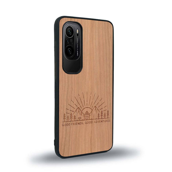 Coque de protection en bois véritable fabriquée en France pour Xiaomi Mi 11i sur le thème chill et nature avec un motif représentant un levé de soleil sur un paysage de montagne avec des sapins et un chalet et la phrase "Good friends, good adventure"