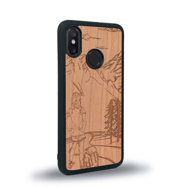 Coque de protection en bois véritable fabriquée en France pour Xiaomi Mi 8 sur le thème de la randonnée en montagne et de l'aventure avec une gravure représentant une femme de dos face à un paysage de nature