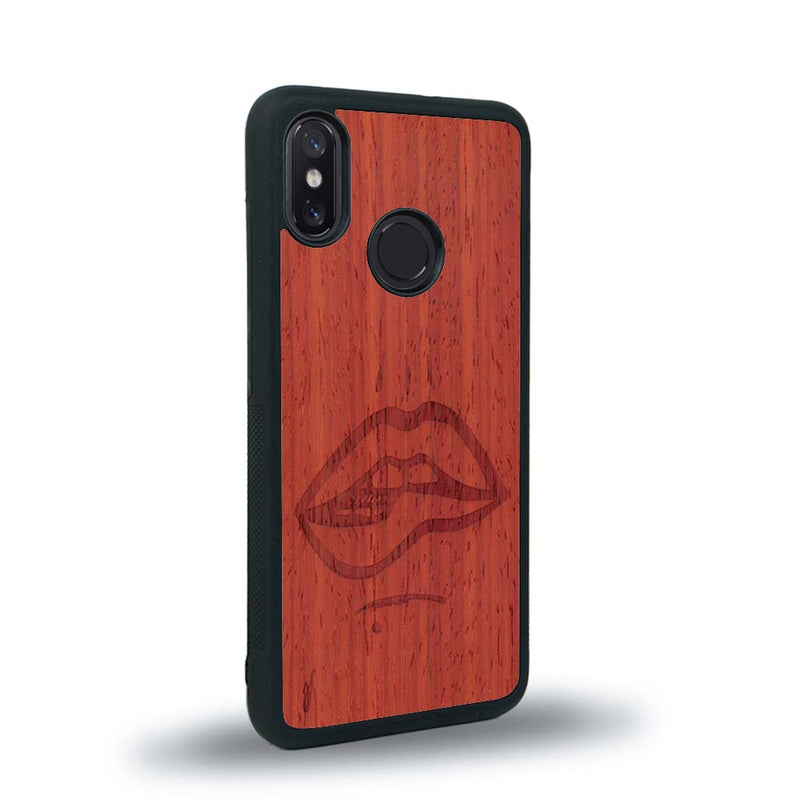 Coque de protection en bois véritable fabriquée en France pour Xiaomi Mi 8 représentant de manière minimaliste une bouche de féminine se mordant le coin de la lèvre de manière sensuelle dessinée à la main par l'artiste Maud Dabs