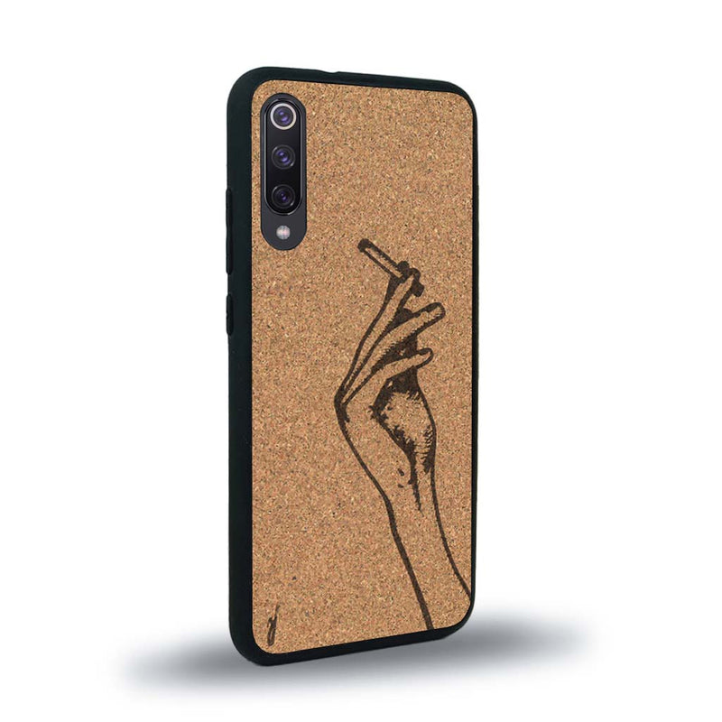 Coque de protection en bois véritable fabriquée en France pour Xiaomi Mi 9SE représentant une main de femme tenant une cigarette de type line art en collaboration avec l'artiste Maud Dabs