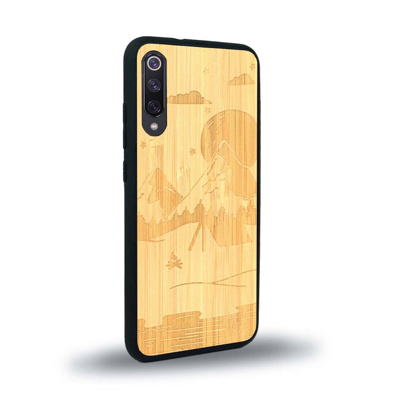 Coque de protection en bois véritable fabriquée en France pour Xiaomi Mi 9SE sur le thème du camping en pleine nature représentant une tente avec un feu de camp entouré de montagnes