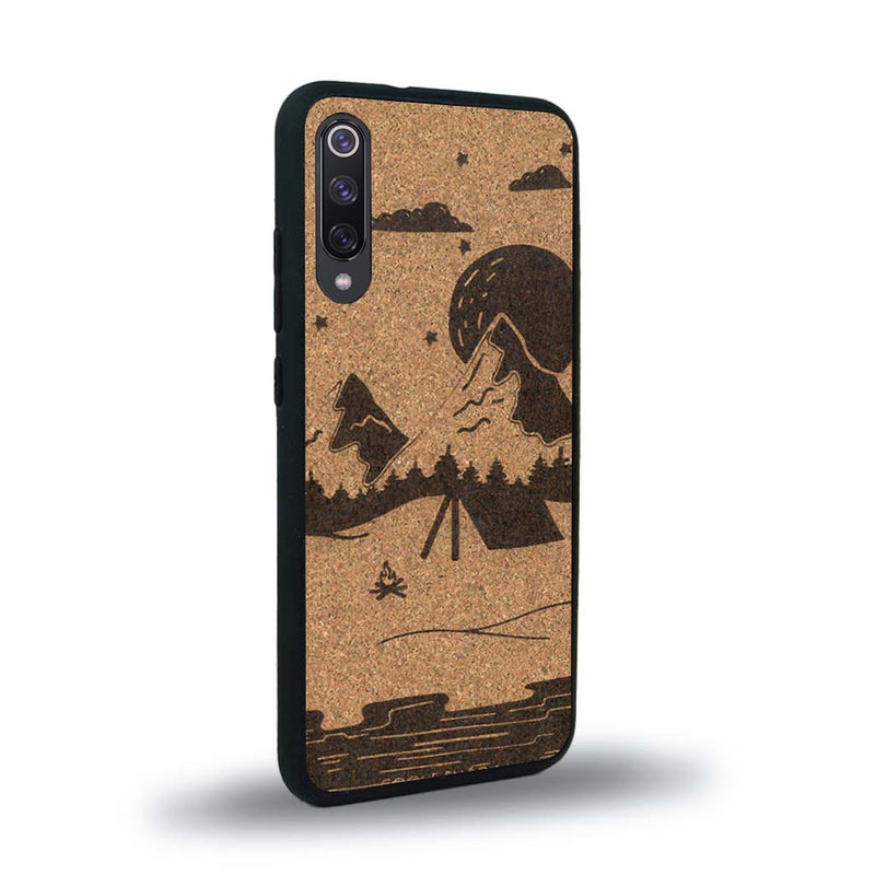 Coque de protection en bois véritable fabriquée en France pour Xiaomi Mi 9SE sur le thème du camping en pleine nature représentant une tente avec un feu de camp entouré de montagnes