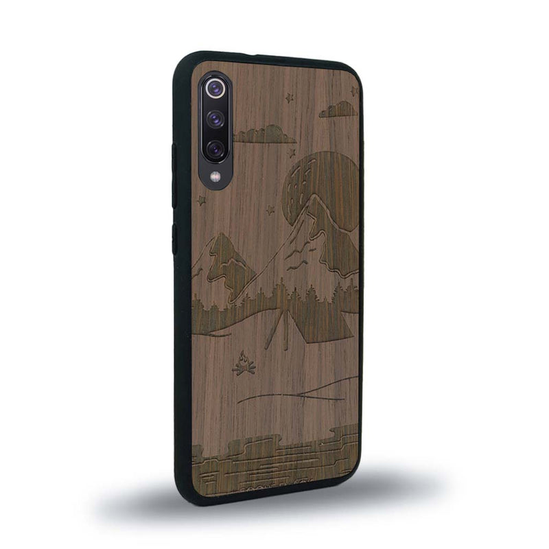 Coque de protection en bois véritable fabriquée en France pour Xiaomi Mi 9SE sur le thème du camping en pleine nature représentant une tente avec un feu de camp entouré de montagnes