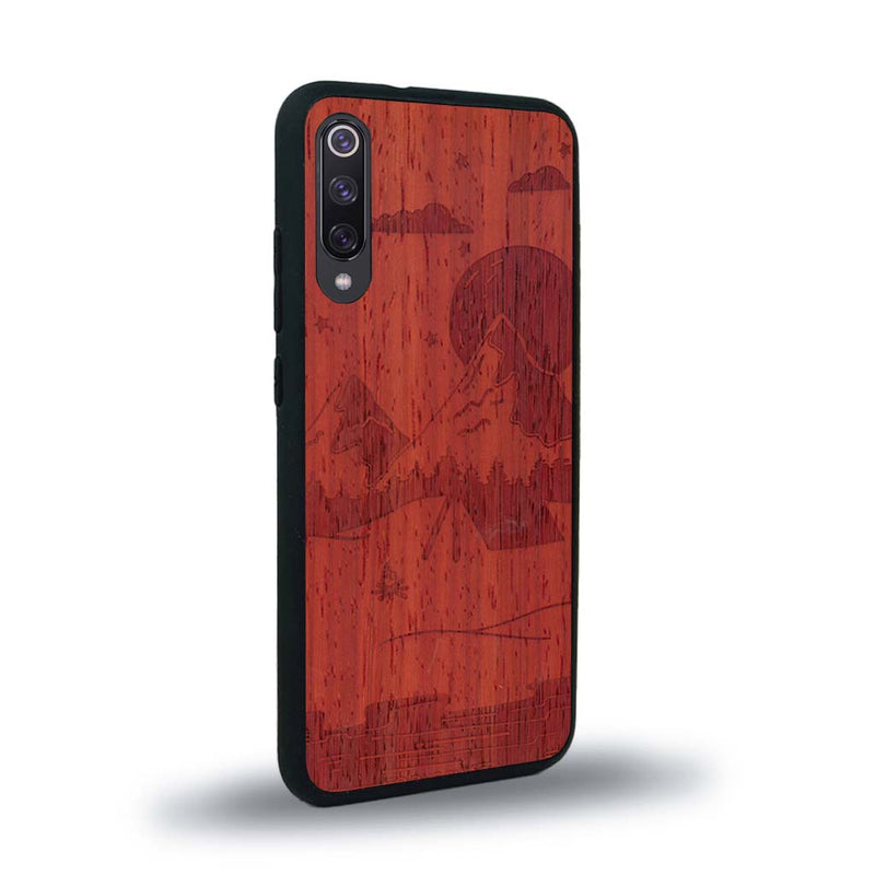 Coque de protection en bois véritable fabriquée en France pour Xiaomi Mi 9SE sur le thème du camping en pleine nature représentant une tente avec un feu de camp entouré de montagnes