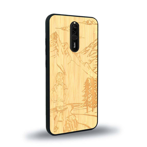 Coque de protection en bois véritable fabriquée en France pour Xiaomi Mi 9T sur le thème de la randonnée en montagne et de l'aventure avec une gravure représentant une femme de dos face à un paysage de nature