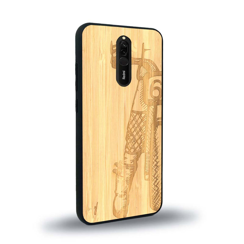 Coque de protection en bois véritable fabriquée en France pour Xiaomi Mi 9T représentant une vue de face d'une femme sur une moto vintage dessinée à la main par l'artiste Maud Dabs