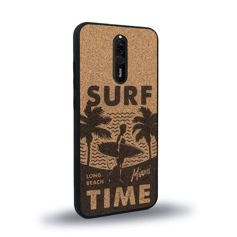 Coque de protection en bois véritable fabriquée en France pour Xiaomi Mi 9T sur le thème chill avec un motif représentant une silouhette tenant une planche de surf sur une plage entouré de palmiers et les mots "Surf Time Long Beach Miami"