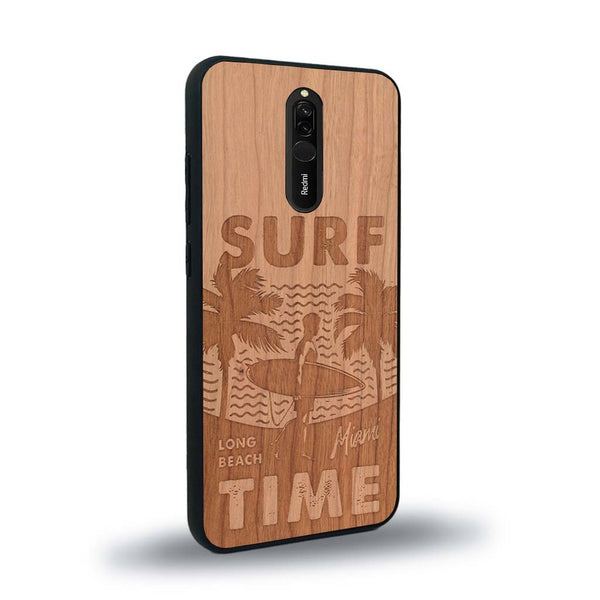 Coque de protection en bois véritable fabriquée en France pour Xiaomi Mi 9T sur le thème chill avec un motif représentant une silouhette tenant une planche de surf sur une plage entouré de palmiers et les mots "Surf Time Long Beach Miami"