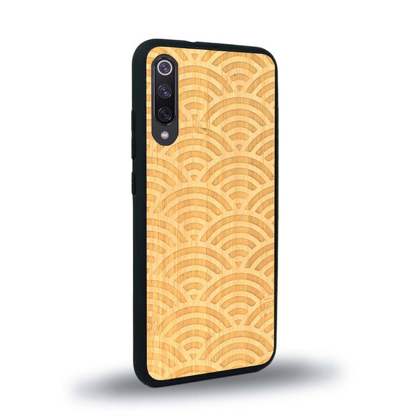 Coque de protection en bois véritable fabriquée en France pour Xiaomi Mi A3 baptisée "La Sinjak" avec un motif de gravure abstrait représentant la répétition d'un symbole wifi