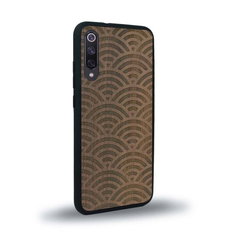 Coque de protection en bois véritable fabriquée en France pour Xiaomi Mi A3 baptisée "La Sinjak" avec un motif de gravure abstrait représentant la répétition d'un symbole wifi