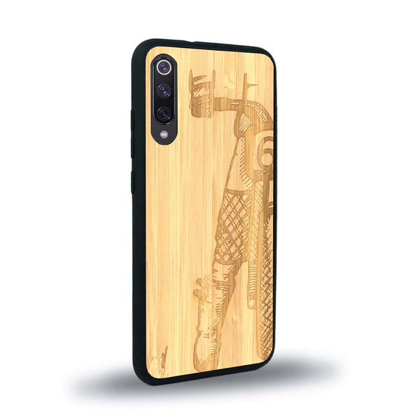 Coque de protection en bois véritable fabriquée en France pour Xiaomi Mi A3 représentant une vue de face d'une femme sur une moto vintage dessinée à la main par l'artiste Maud Dabs