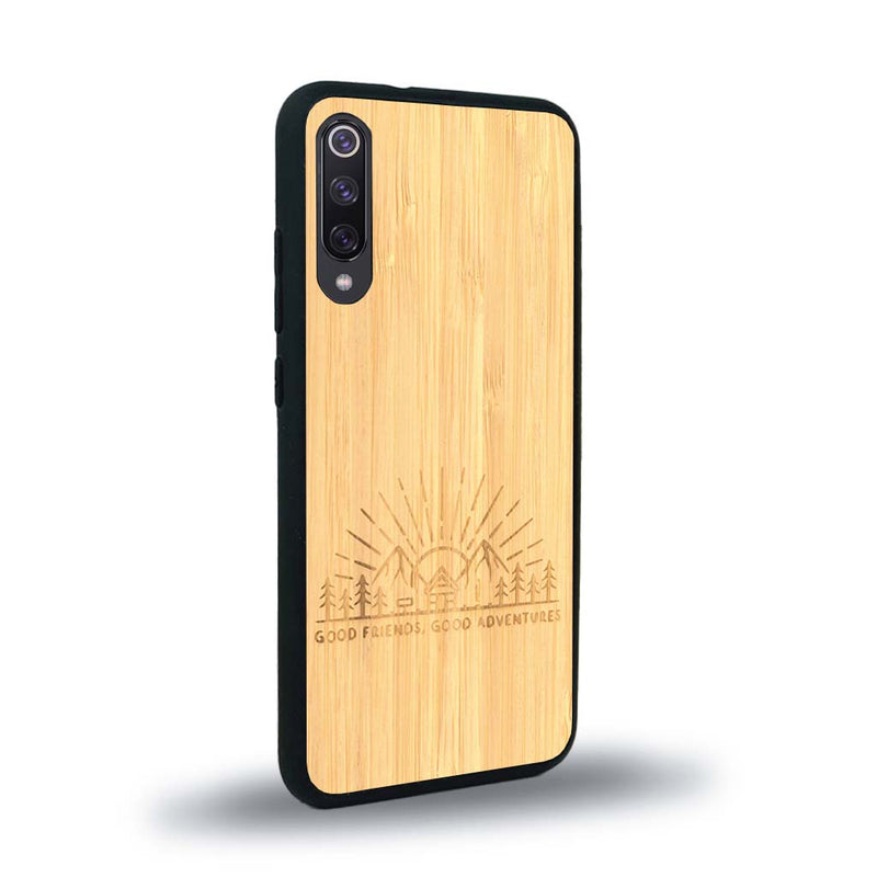 Coque de protection en bois véritable fabriquée en France pour Xiaomi Mi A3 sur le thème chill et nature avec un motif représentant un levé de soleil sur un paysage de montagne avec des sapins et un chalet et la phrase "Good friends, good adventure"